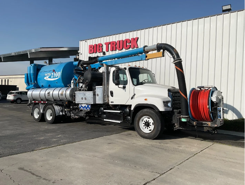 The vacuum truck is parked on the street.