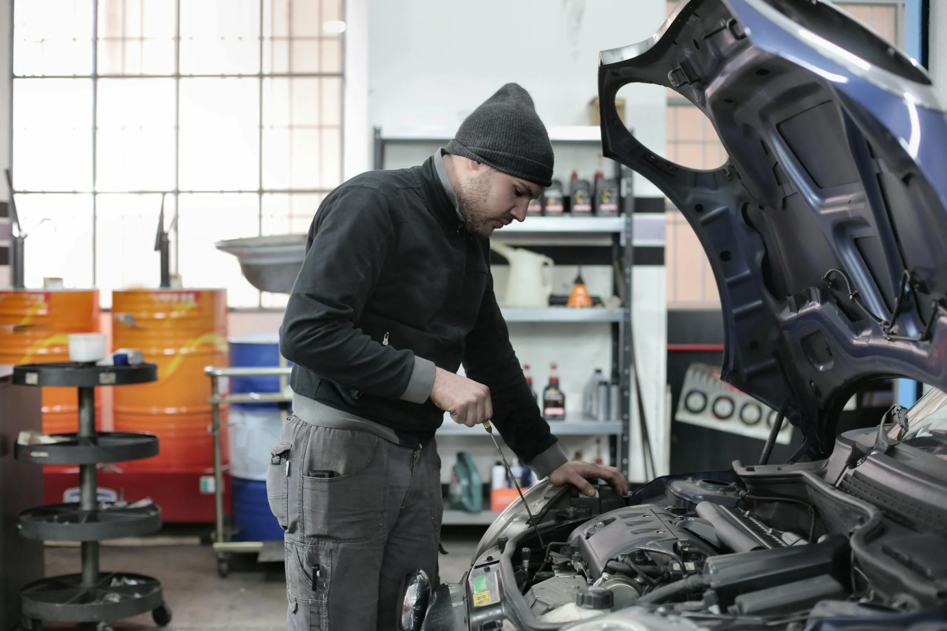 A car mechanic carefully inspecting the air filter and engine area for any issues.